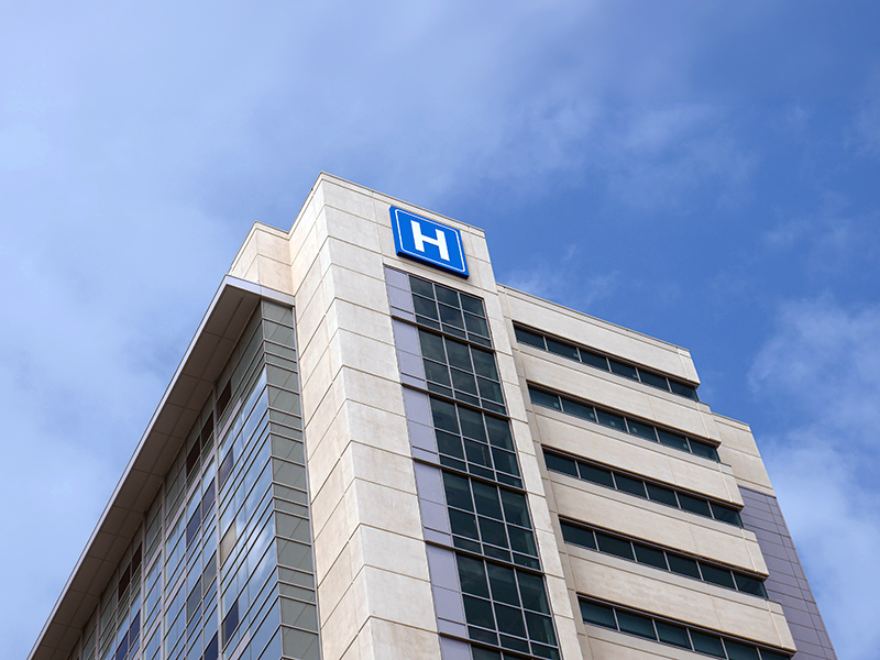 Torre de un hospital moderno bajo el cielo azul.