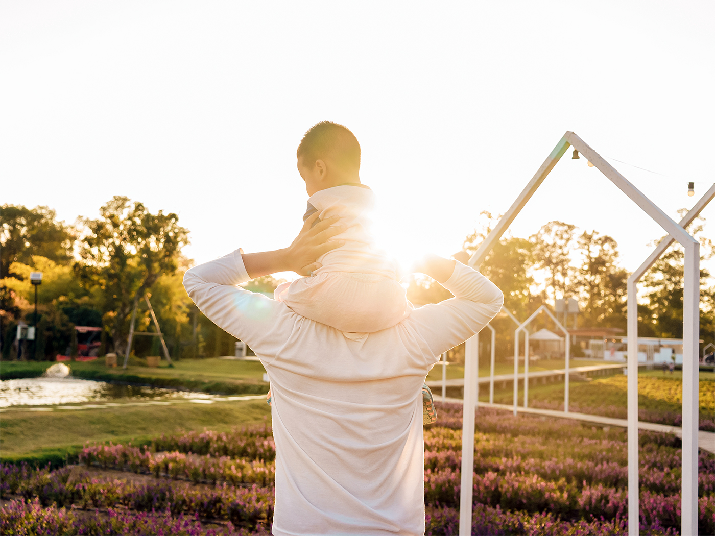  Adulto con un niño a hombros al atardecer.
