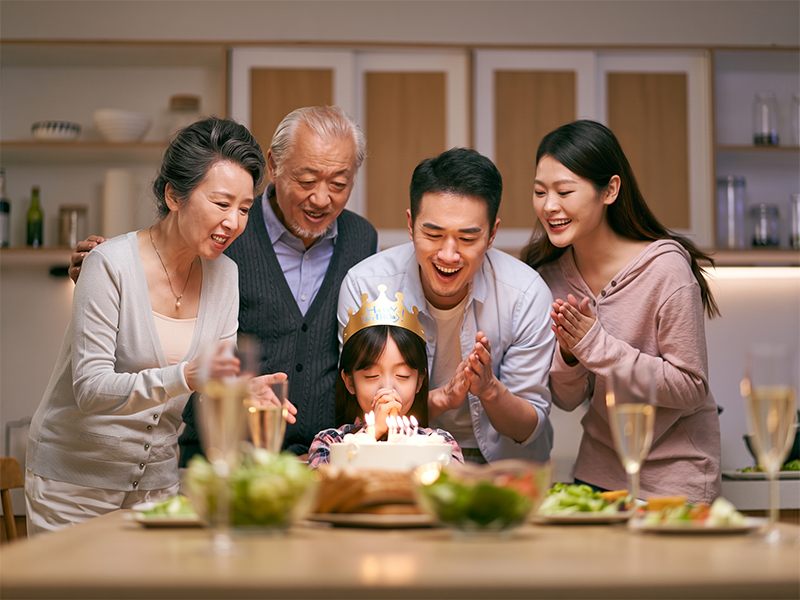 Una familia de tres generaciones celebra el cumpleaños de la pequeña.