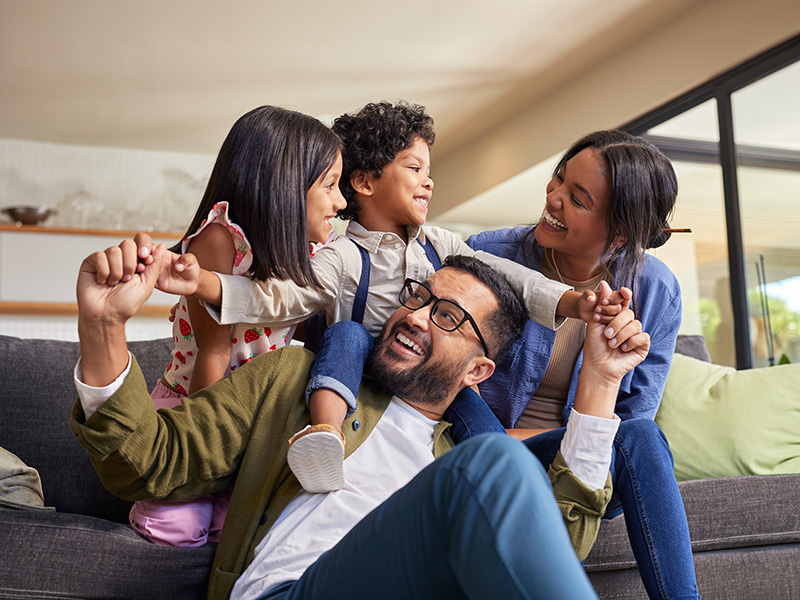 Familia jugando junta en el sofá del salón.